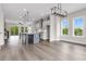 Open-concept living room with modern lighting, hardwood floors, and expansive windows at 557 Red Clay Farm Ln, Suwanee, GA 30024