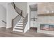 A modern living room featuring a tile fireplace, wood floors, and a staircase, enhancing the home's stylish appeal at 557 Red Clay Farm Ln, Suwanee, GA 30024