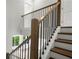 A staircase showcasing wood railings with iron spindles, and wood steps adding architectural charm to the home at 557 Red Clay Farm Ln, Suwanee, GA 30024