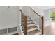 Staircase with wood and black metal handrail and adjacent hall tree with storage at 557 Red Clay Farm Ln, Suwanee, GA 30024
