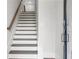 Inviting stairway featuring wood handrail and white risers leading to upper levels of the home at 557 Red Clay Farm Ln, Suwanee, GA 30024