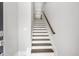 Entryway view of stairs with hardwood treads, white risers, and a wooden handrail at 577 Red Clay Farm Ln, Suwanee, GA 30024