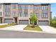 Modern brick townhomes feature attached garages, professional landscaping, and concrete driveways at 577 Red Clay Farm Ln, Suwanee, GA 30024