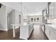 Modern open-concept kitchen boasts white cabinets, island with seating, and stainless steel appliances at 577 Red Clay Farm Ln, Suwanee, GA 30024
