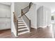 Wood staircase with white risers and black iron balusters at 577 Red Clay Farm Ln, Suwanee, GA 30024