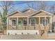 Charming home featuring tan siding, white trim, inviting front porch and a delightful green front door at 385 Arthur Sw St, Atlanta, GA 30310