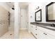 A well-lit bathroom featuring a double sink vanity, walk-in shower and tile flooring at 475 Letchas Ln, Alpharetta, GA 30009