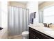 Cozy bathroom features dark wood vanity with cream countertop, mirror and combination shower-tub at 475 Letchas Ln, Alpharetta, GA 30009