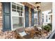 Cozy front porch seating area with outdoor furniture and black shutters at 475 Letchas Ln, Alpharetta, GA 30009