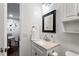 Modern bathroom with vanity, framed mirror, and white walls; a door leads to another room at 8834 Applegate Ln, Atlanta, GA 30350