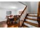 Warm dining area with hardwood floors, adjacent staircase, large wooden table and chairs at 8834 Applegate Ln, Atlanta, GA 30350