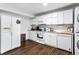 Well-lit kitchenette complete with full-size refrigerator, laundry appliances and modern white cabinets at 8834 Applegate Ln, Atlanta, GA 30350