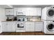 Well-lit kitchenette complete with stacked laundry appliances and modern white cabinets at 8834 Applegate Ln, Atlanta, GA 30350