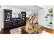 Cozy living room featuring dark entertainment center, hardwood floors, and staircase at 8834 Applegate Ln, Atlanta, GA 30350