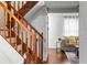 Staircase featuring wooden banister and white risers adjacent to the living room and hardwood floors at 8834 Applegate Ln, Atlanta, GA 30350