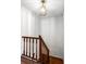 Wooden staircase with decorative hanging light fixture in a white walled space at 8834 Applegate Ln, Atlanta, GA 30350