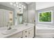 Bathroom with double sinks, a garden tub, and a window for natural light at 11637 Brown Bridge Rd, Covington, GA 30016