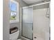 Bathroom featuring a glass door shower and a toilet, with a window overlooking the outside at 11637 Brown Bridge Rd, Covington, GA 30016