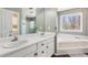 Bathroom with dual sinks, white cabinets, a soaking tub with a view, and a separate room with toilet and shower at 11637 Brown Bridge Rd, Covington, GA 30016