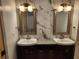 Bathroom featuring double sinks, mirrors, and modern lighting fixtures at 11637 Brown Bridge Rd, Covington, GA 30016