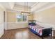 Bright bedroom with a tray ceiling, single bed, wood trim, and a large window overlooking the yard at 11637 Brown Bridge Rd, Covington, GA 30016