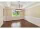Dining room with wood-look floors, decorative lighting, and wainscoting at 11637 Brown Bridge Rd, Covington, GA 30016