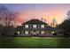 Spacious two-story home featuring a wraparound porch and lush front lawn against a beautiful sky at 11637 Brown Bridge Rd, Covington, GA 30016