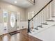 Light filled foyer with hardwood floors, paneled walls, and a striking staircase at 11637 Brown Bridge Rd, Covington, GA 30016