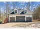 Three-car garage with gray doors and exterior lighting at 11637 Brown Bridge Rd, Covington, GA 30016