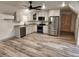 Modern kitchen with stainless steel appliances, white cabinets, and wood-look flooring at 11637 Brown Bridge Rd, Covington, GA 30016