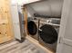 Modern, gray, front-load Samsung washer and dryer in a laundry closet with wood-look floors at 11637 Brown Bridge Rd, Covington, GA 30016