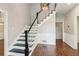 Staircase with wood-look floors and a black and white banister design at 11637 Brown Bridge Rd, Covington, GA 30016
