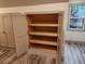 Open storage cabinet with light wood shelving, gray doors, and wood-look floors at 11637 Brown Bridge Rd, Covington, GA 30016