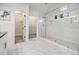 White bathroom with a glass-enclosed shower, tiled walls, and an open door to a closet at 1350 Bluefield Sw Dr, Atlanta, GA 30310