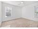 Empty bedroom with neutral walls, carpeted floors, two large windows, and a ceiling fan at 1350 Bluefield Sw Dr, Atlanta, GA 30310