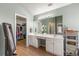 Bright bathroom featuring double vanity, large mirror, and walk-in closet for ample storage space at 2955 Victoria Park Dr, Buford, GA 30519