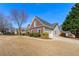 Brick and vinyl home with attached garage, long driveway and manicured lawn at 2955 Victoria Park Dr, Buford, GA 30519