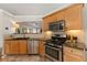 Well-lit kitchen featuring stainless steel appliances, wood cabinetry, and granite countertops at 2955 Victoria Park Dr, Buford, GA 30519