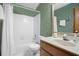 Bathroom with green floral wallpaper, a shower-tub combination, and a sink with marble countertop at 425 Ridgemont Dr, Lawrenceville, GA 30046