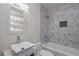 Modern bathroom with marble tiling, vessel sink, and shower-tub combo at 1006 Byron Sw Dr, Atlanta, GA 30310