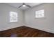 Sunlit bedroom featuring hardwood floors, two windows, and a contemporary ceiling fan at 1006 Byron Sw Dr, Atlanta, GA 30310