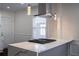 Modern kitchen island with cooktop and stainless steel range hood with pendant lights at 1006 Byron Sw Dr, Atlanta, GA 30310