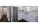 Bright kitchen with stainless fridge, white cabinets, herringbone backsplash, and marble countertop at 1006 Byron Sw Dr, Atlanta, GA 30310