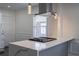 Modern kitchen island with cooktop and stainless steel range hood with pendant lights at 1006 Byron Sw Dr, Atlanta, GA 30310