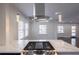 Marble kitchen island with cooktop and stainless steel hood and pendant lights at 1006 Byron Sw Dr, Atlanta, GA 30310