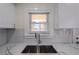 Kitchen with white herringbone backsplash and stainless sink, faucet, and cabinet hardware at 1006 Byron Sw Dr, Atlanta, GA 30310