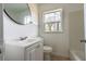 Cozy bathroom featuring a white vanity with a round mirror and a window offering natural light at 122 Goldie Se Dr, Marietta, GA 30067