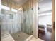 Modern tiled shower with glass enclosure and bench seating, plus a partial view of the main bedroom at 131 City View Ne Ct, Atlanta, GA 30308