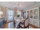 Elegant dining room with a chandelier, large window, white china cabinet, and a table set for a meal at 1953 Graystone Pkwy, Grayson, GA 30017