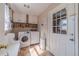 Functional laundry room with washer, dryer, storage cabinets, a utility sink, and plenty of natural light at 1953 Graystone Pkwy, Grayson, GA 30017